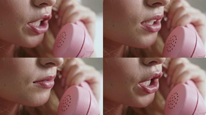 女人在粉红色的固定电话上讲话时，嘴唇和嘴巴上的特写镜头-极端特写镜头