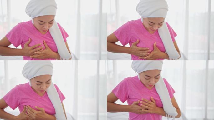 亚洲女性乳房疼痛触摸胸部在白色背景，不健康的女孩抓住胸部，感到急性疼痛和害怕的心脏病发作，梗塞或乳腺