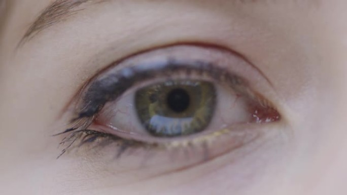 特写女性绿眼看镜头和眨眼，视力手术和干眼症概念