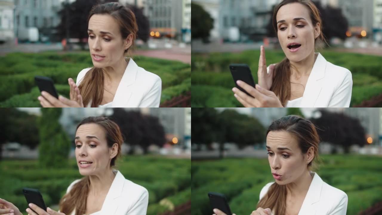 恼怒的女商人在city walk的智能手机上通过视频通话发誓。
