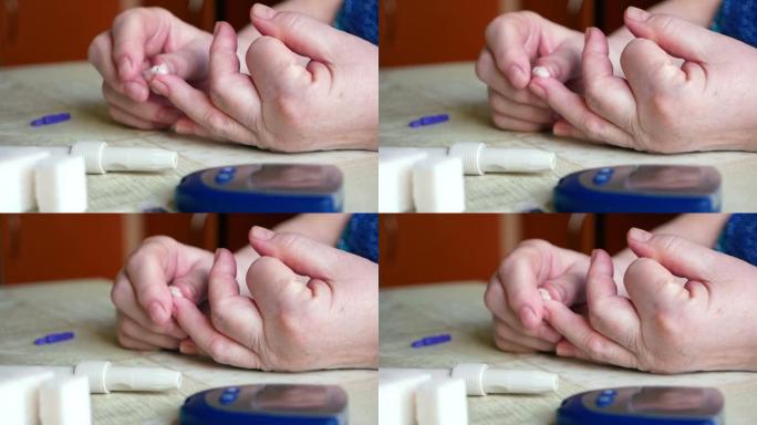 糖尿病主题。近距离拍摄血糖仪的焦点消失，背景中一名患有糖尿病的妇女在家中进行血糖测试后的手。选择性聚