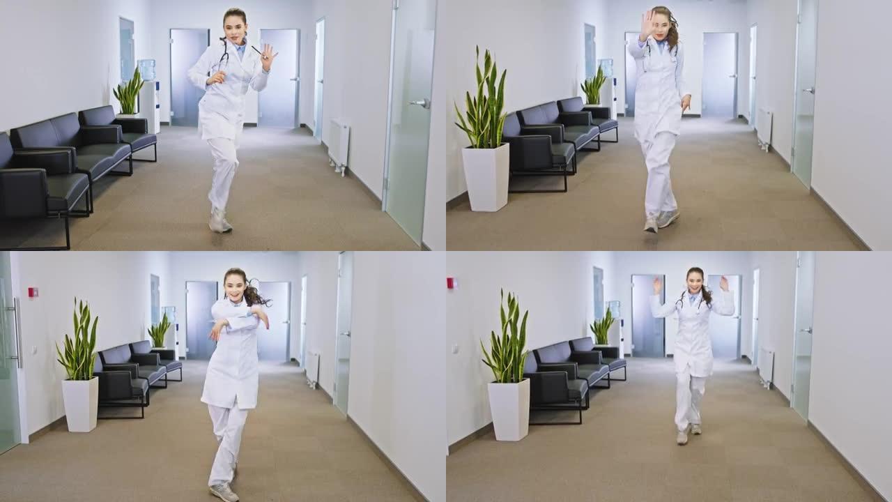 微笑着的年轻医生女士在镜头前兴奋地跳舞，享受着在工作场所的时光。在阿里·阿列克谢迷你上拍摄
