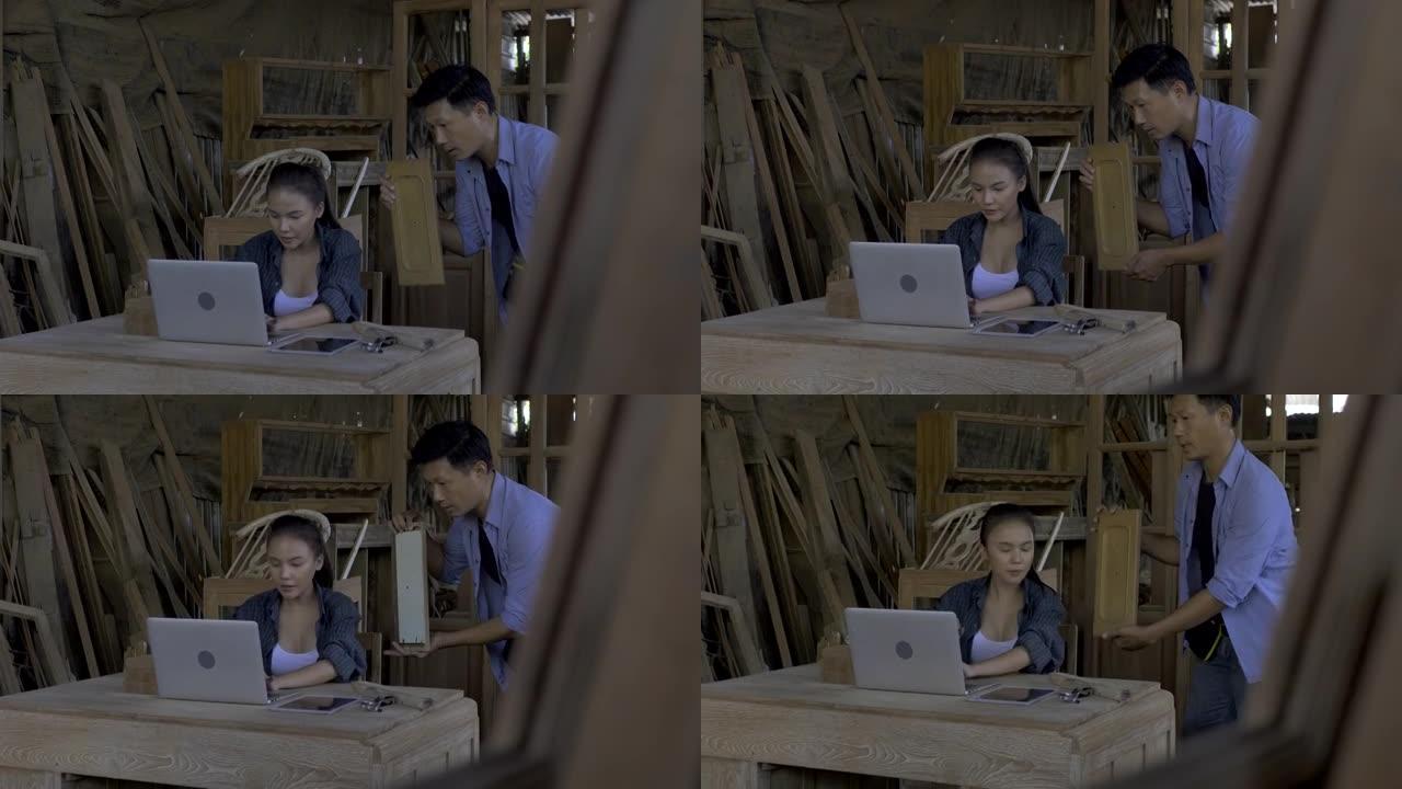 亚洲男女都是手握平板电脑的熟练木匠，在网上卖木家具，在网站上卖东西