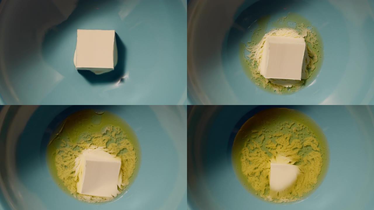 在蓝色碗中融化的黄油立方体，顶视图，延时