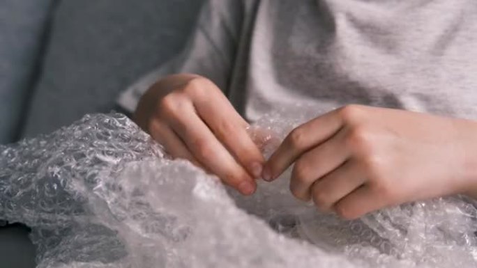 儿童手玩塑料气泡包装的特写。神经，压力，平静。