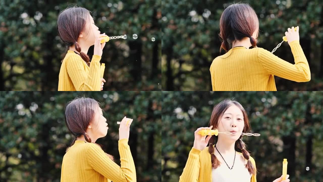 快乐的中国年轻女子在阳光明媚的日子里玩泡泡，4k慢动作镜头。