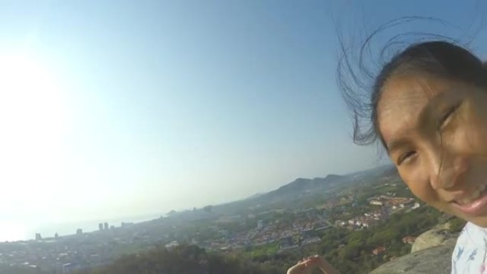 快乐的亚洲女孩在山顶上放松，用家庭、生活方式的理念看风景。