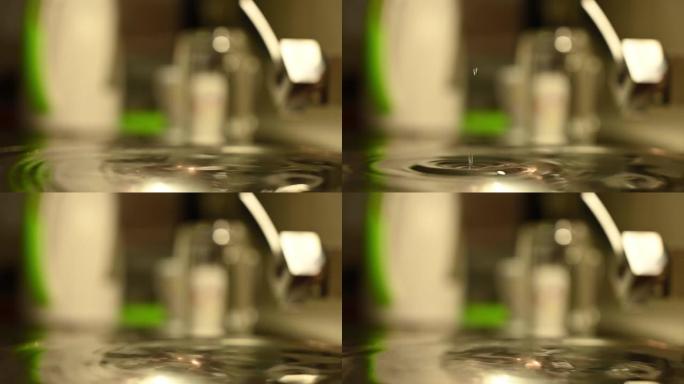 一滴水落入盛水容器中的慢动作镜头。家里有故障的水龙头