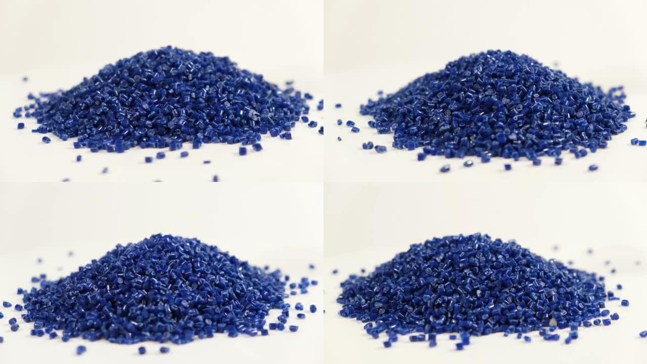 由聚丙烯制成的次级颗粒，深色塑料颗粒会碎到桌子上。工业用颗粒塑料原料。聚合物树脂。生塑料回收概念。