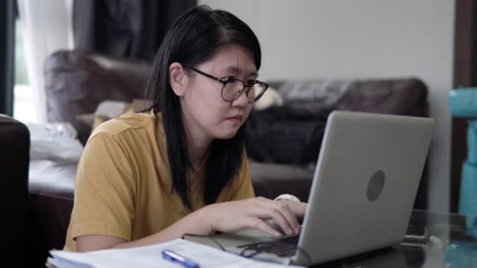 亚洲女性自由职业者在家工作笔记本电脑。