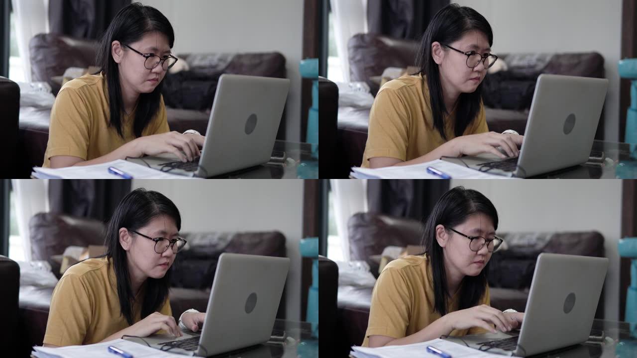 亚洲女性自由职业者在家工作笔记本电脑。