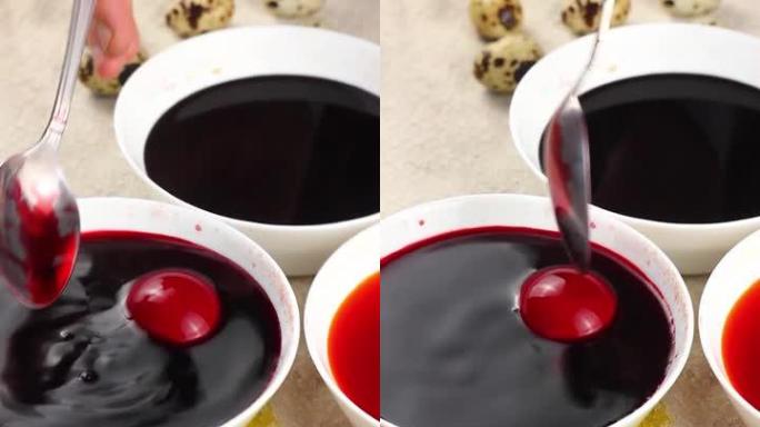 高加索儿童用金属勺子画一个复活节彩蛋，然后将其浸入带有红色染料的白色碗中。复活节假期的概念。垂直视频