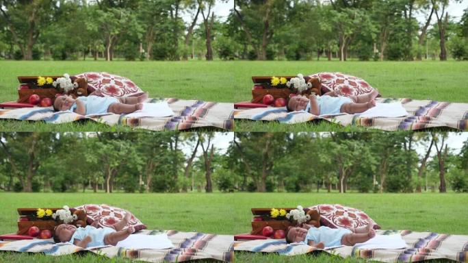 非洲蹒跚学步的孩子躺在公园的垫子上，移动手和腿，哭泣。