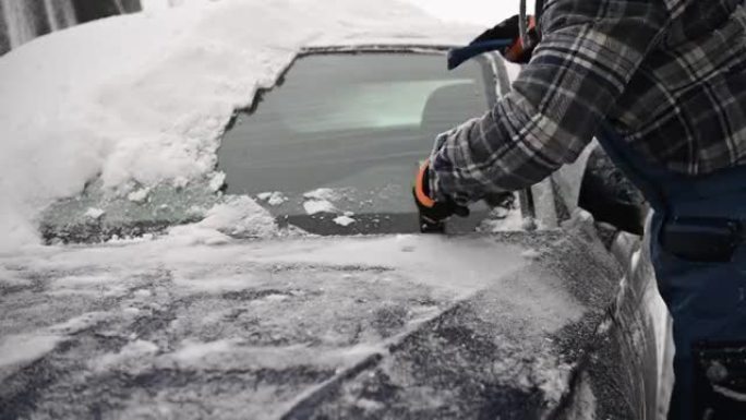 驾驶员从汽车挡风玻璃上清除冰雪