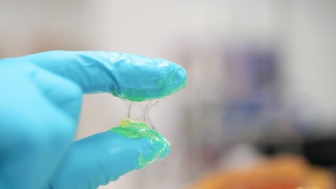 技术人员通过用两根手指压在润滑脂上测试锂润滑脂NLGI 3的质地，并在实验室中查看粘性和外观。戴着丁