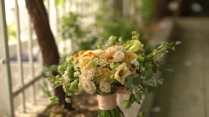 新娘的玫瑰花，lisianthus和桉树小树枝站在铁艺围栏上
