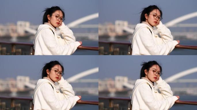 中国年轻女子闭着眼睛享受黄浦江的微风，4k慢动作镜头。