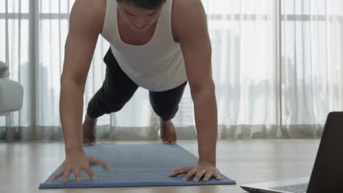 在新型冠状病毒肺炎爆发期间，亚洲男子在家锻炼，在健身房关闭时铺板。