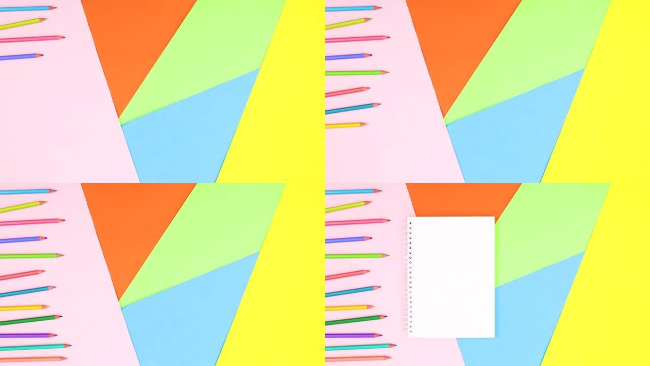 彩色铅笔和打开笔记本的文字出现在彩色主题上。停止运动