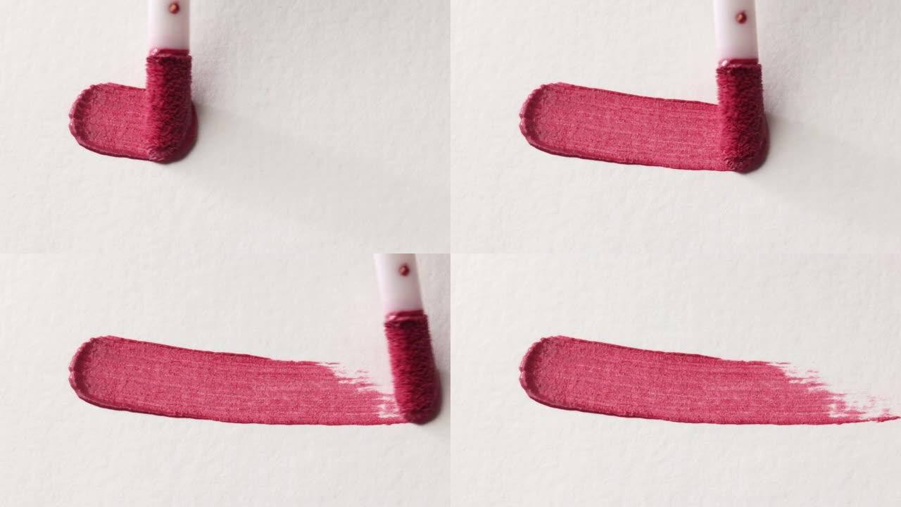 粉色化妆品唇彩涂片例子涂在白色背景上，涂刷特写
