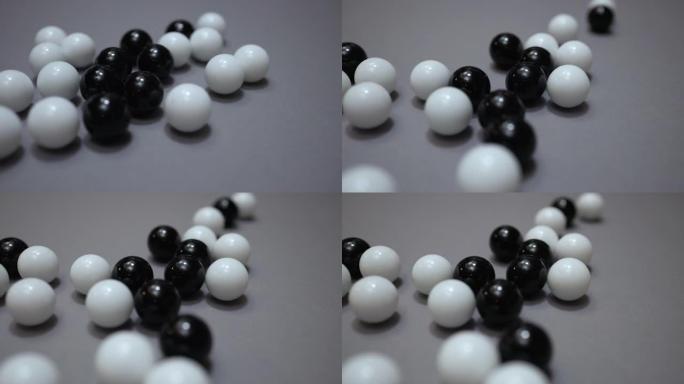 一组黑色和白色的球在灰色表面上滚动