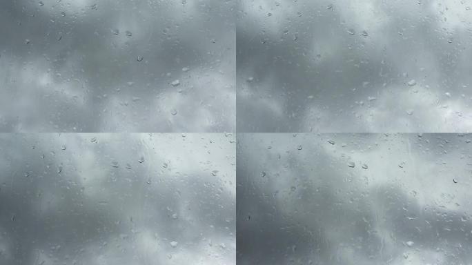 时间流逝的雨滴在玻璃窗上的乌云前。