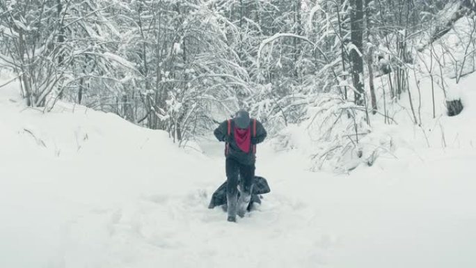 男子拖着沉重的临时担架穿过白雪皑皑的