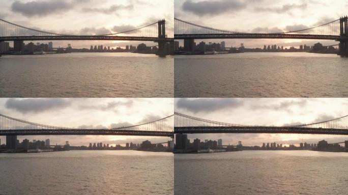 空中无人驾驶飞机在日出时向纽约市海平面的曼哈顿大桥飞行