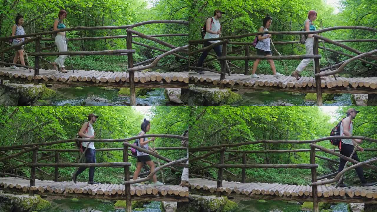 一群游客走过一座桥，桥上有清澈的水。