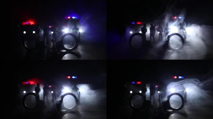 警察在晚上突袭，你被逮捕了。手铐的轮廓，背面有警车。在有雾的背景下闪烁的红色和蓝色警灯的图像。选择性