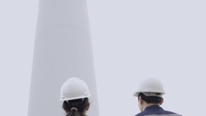 两名亚洲工程师检查工程师在泰国风电场中准备和进度检查具有安全性的风力涡轮机。