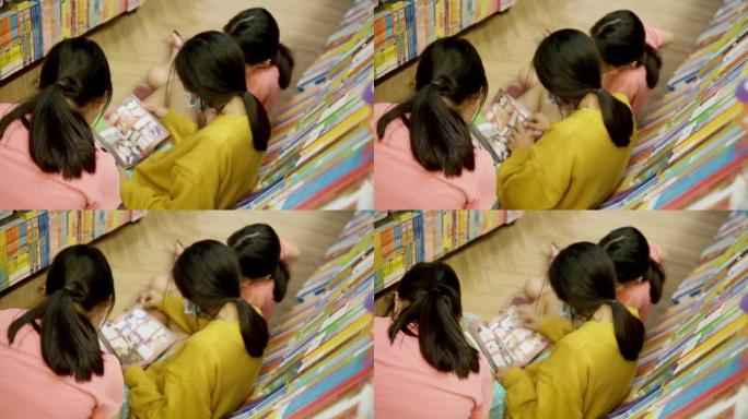 快乐的亚洲儿童看书，一起坐在书店的地板上，生活理念。