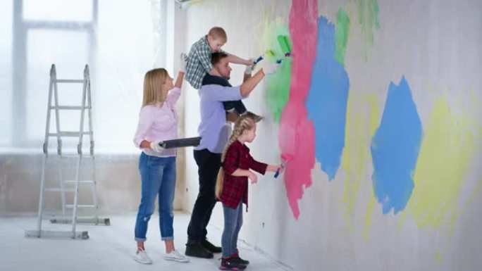 有创意的家庭，父亲脖子上有患有唐氏综合症的男孩，姐姐正在新公寓里完成工作，并在墙壁上涂漆，用滚筒彩色