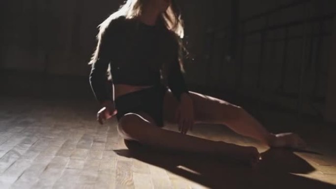 美丽的年轻芭蕾舞演员在深夜在机器附近的健身房训练时失败了