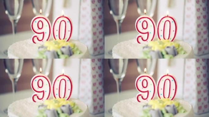 生日蜡烛作为90号90在桌上的甜蛋糕上，90岁生日，调子视频