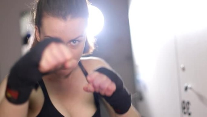 运动女子在健身房训练时练习拳打。