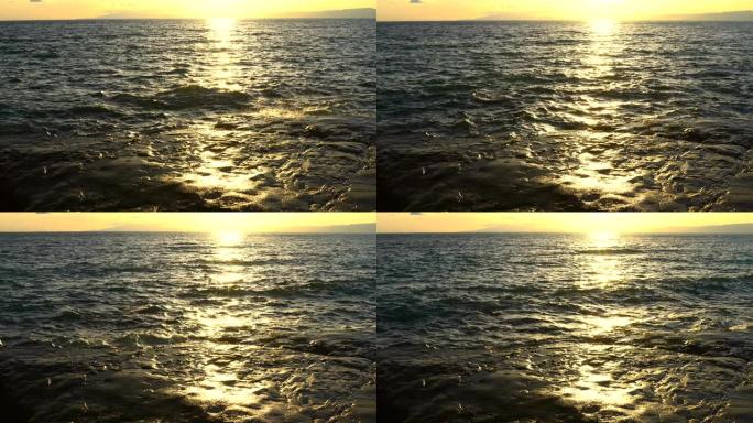 日落时海浪在岩石海岸上飞溅