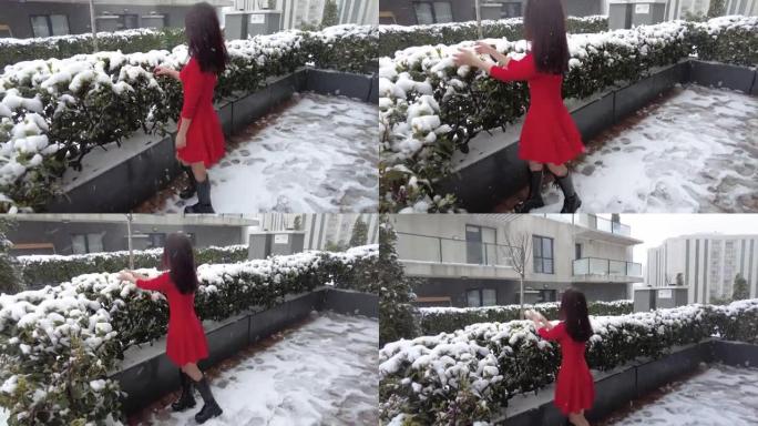 穿着红色衣服的年轻女子在雪地里玩耍