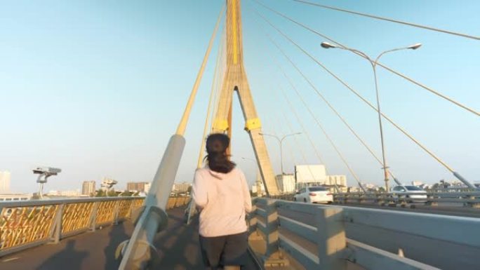 亚洲年轻女子跑过桥