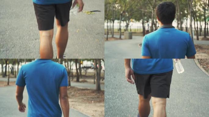 年轻的亚洲男子运动员在公园跑步后走路并拿着水瓶。