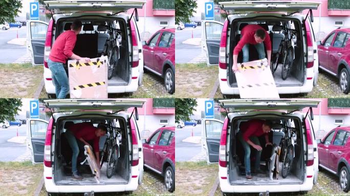 人把一件东西装进汽车后备箱。他把物品放在小货车里。