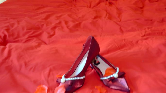 红色婚床上的婚鞋高跟鞋