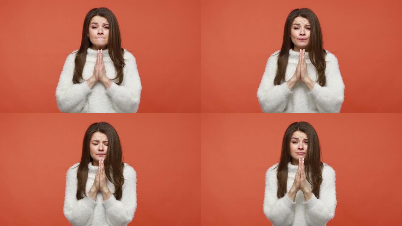 愁眉苦脸的女人双手合十祈祷，祈求原谅，道歉