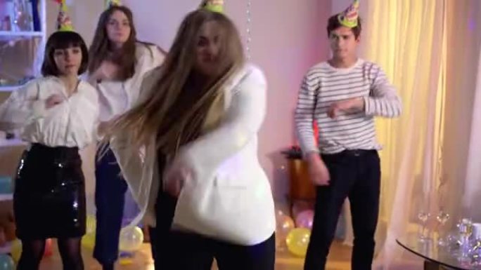正面大码女人在背景下与朋友跳舞的肖像。快乐无忧无虑的高加索女士在生日派对上看着相机和客人玩得开心。庆