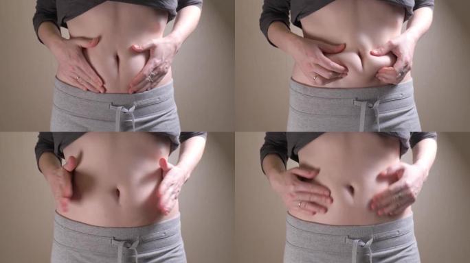 女性腹部特写慢动作。显示腹部脂肪的女人