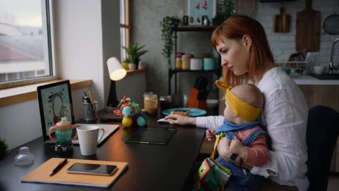 年轻的母亲在她的家庭办公室与她的女婴一起工作