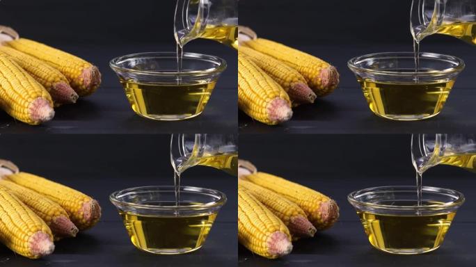 将玉米油倒入玻璃瓶中，并在质朴的背景下将玉米粒和玉米粒干燥。食用油成分
