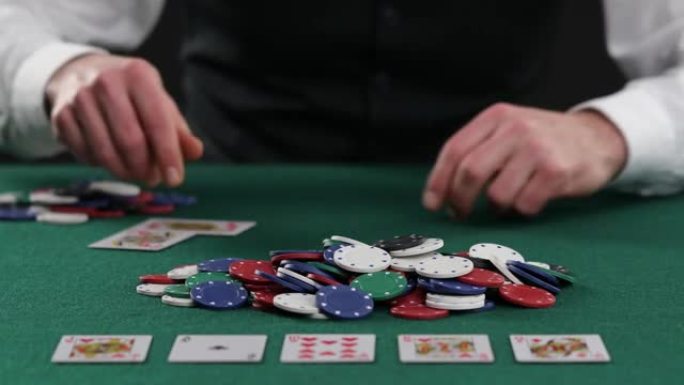 扑克玩家拉了一堆筹码，大赢，大奖，成功的游戏。财富，运气，赌博。成功的玩家将筹码堆积在扑克桌上