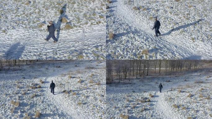 在苏格兰西南部积雪覆盖的人行道上，一名高级男子独自行走时揉手的高角度视图