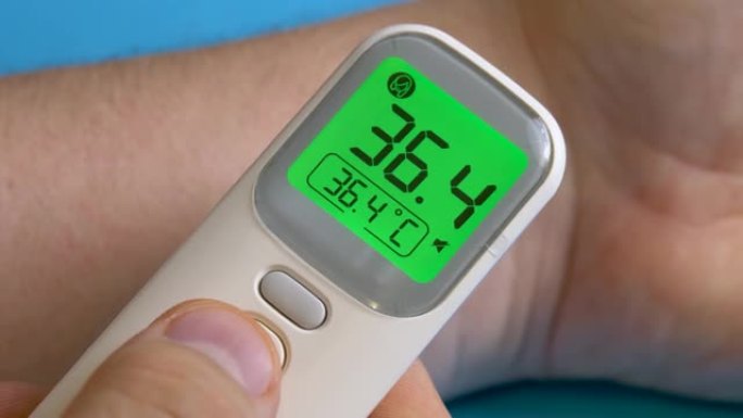 无法辨认的人测量手头的温度。数字温度计。疾病预防。诊断医疗工具。冠状病毒时间、检疫和爆发的自我药物治